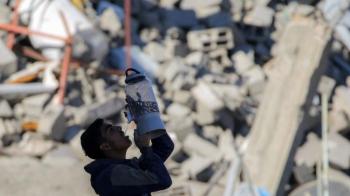 Um menino bebe água junto aos escombros de um prédio desabado em Rafah, Gaza. . (Foto de Eyad Baba / AFP)  (AFP or licensors) Notícias Católicas